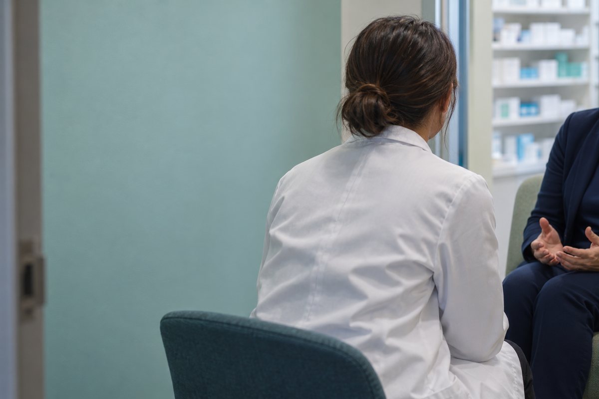 薬局の別室で職場の困り事を相談する職員